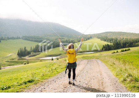Young woman is having fun, walking through valley with stunning natural panorama. Adventure concept. Young woman is having fun, walking through valley with stunning natural panorama. Adventure concept. 111990116