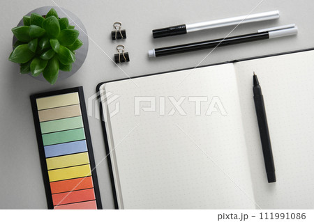 Empty notebook page for your text with black and white school and office stationery on gray background. Flatly. Empty notebook page for your text with black and white school and office stationery on gray background. Flatly. 111991086