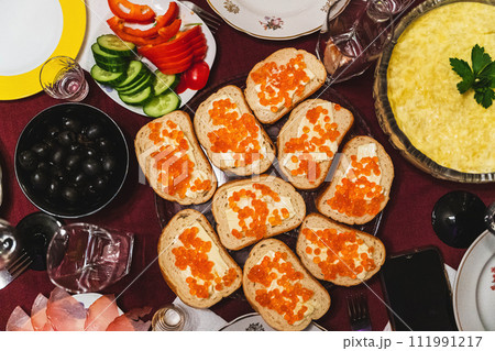 Homemade festive lunch with sandwiches, red caviar, butter, olives 111991217