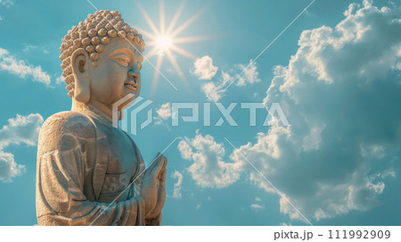 Golden Buddha statue in the clouds on the left. Minimalistic sky background with sun rays Golden Buddha statue in the clouds on the left. Minimalistic sky background with sun rays 111992909