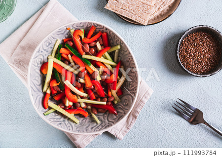 Vegetarian salad of red beans, cucumber and bell pepper in a bowl on the table top view Vegetarian salad of red beans, cucumber and bell pepper in a bowl on the table top view 111993784