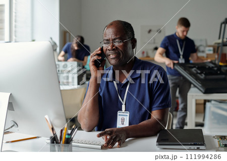 Man speaking to client on smartphone Man speaking to client on smartphone 111994286