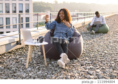 African American blogger demonstrating city view for subscribers. 111994804