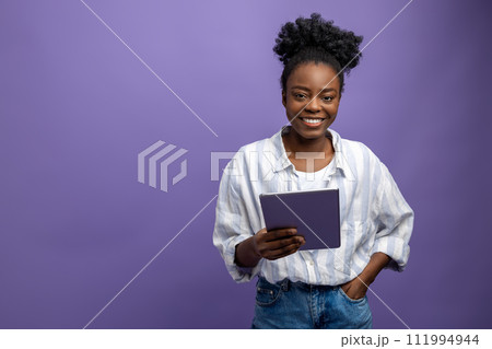 Curly-haired dark-skinned young woman smiling widely Curly-haired dark-skinned young woman smiling widely 111994944