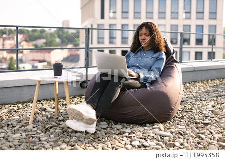 Business woman in casual denim shirt working on laptop. 111995358