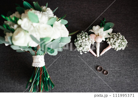 Wedding rings and a bouquet of roses and other flowers Wedding rings and a bouquet of roses and other flowers 111995371