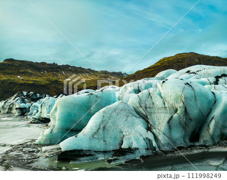 Aerial view of vatnajokull glacier mass, fantastic blue glacier lagoon forming on frozen lake in icelandic region. Spectacular nordic icebergs and glacial ice blocks cracked on icy land. 111998249