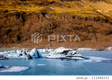 Huge arctic vatnajokull ice mass in iceland, beautiful massive glacier colored with white, blue and green. Frozen floating icebergs in frosty winter scenery and natural icy landscape. 111998252