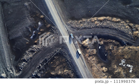 Arctic landscape in iceland, beautiful icelandic fields and roads in countryside. Natural frozen black lands with snow forming scandinavian scenery. Drone shot. Aerial view. Arctic landscape in iceland, beautiful icelandic fields and roads in countryside. Natural frozen black lands with snow forming scandinavian scenery. Drone shot. Aerial view. 111998376