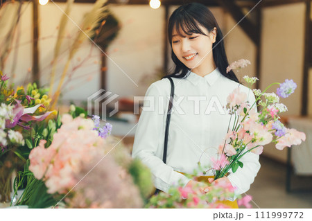 花屋でお花を選ぶ女性 111999772