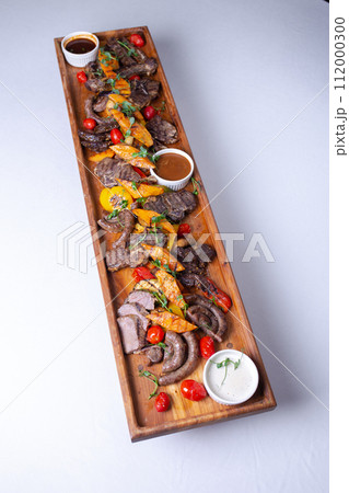 Top view Rustic wooden platter with assorted meats and vegetables 112000300