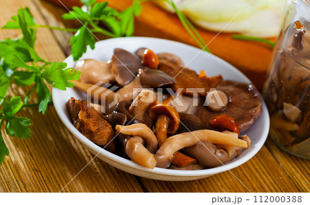 Assorted pickled mushrooms with onions and parsley Assorted pickled mushrooms with onions and parsley 112000388