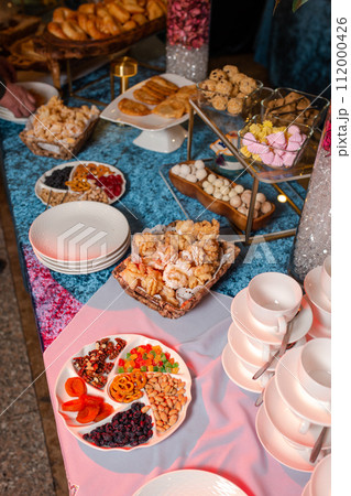 top view of Kazakhstani treats. Delicious pastries and nuts on a blue velvet tablecloth. top view of Kazakhstani treats. Delicious pastries and nuts on a blue velvet tablecloth. 112000426