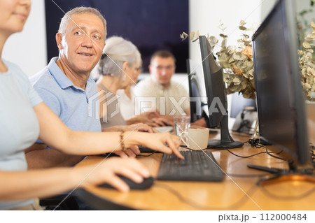 Computer lessons for elderly people in nursing home. Group of seniors learning to use computers in class Computer lessons for elderly people in nursing home. Group of seniors learning to use computers in class 112000484