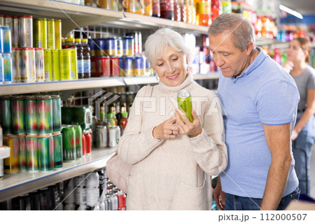 Elderly couple choosing refreshing drinks in supermarket 112000507