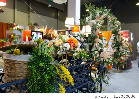 Rustic decor with floral arch, vintage furniture creates a romantic and elegant atmosphere. Rustic decor with floral arch, vintage furniture creates a romantic and elegant atmosphere. 112000636