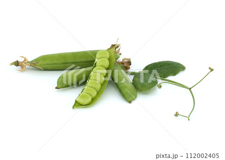 Open pea pod and round green peas inside on white 112002405