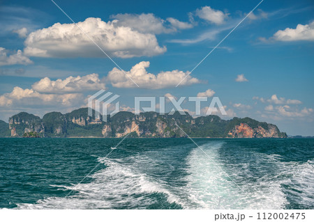 Tropical islands view behind speed boat with ocean blue sea water and white sand beach at Railay Beach, Krabi Thailand nature landscape 112002475