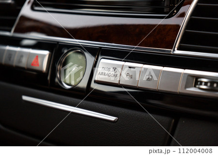 Interior of modern luxury car. Details of automatic transmission gear shift, multimedia control system, car control panel, Air Vent Red emergency button and dashboard inside. Prestige sport automobile Interior of modern luxury car. Details of automatic transmission gear shift, multimedia control system, car control panel, Air Vent Red emergency button and dashboard inside. Prestige sport automobile 112004008
