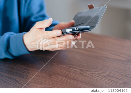 スマホを持つシニア女性の手元 112004165