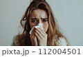 鼻をかむ若い女性 112004501