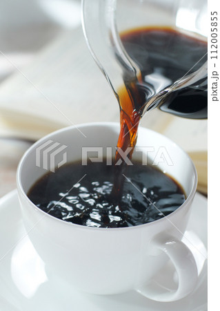 コーヒーカップにコーヒーを注ぐ 読書中のブレイクタイム コーヒーカップにコーヒーを注ぐ 読書中のブレイクタイム 112005855