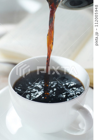 コーヒーカップにコーヒーを注ぐ 読書中のブレイクタイム コーヒーカップにコーヒーを注ぐ 読書中のブレイクタイム 112005948
