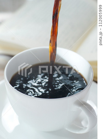 コーヒーカップにコーヒーを注ぐ 読書中のブレイクタイム 112005999