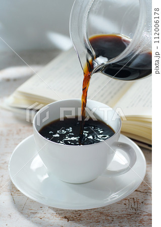 コーヒーカップにコーヒーを注ぐ 読書中のブレイクタイム コーヒーカップにコーヒーを注ぐ 読書中のブレイクタイム 112006178