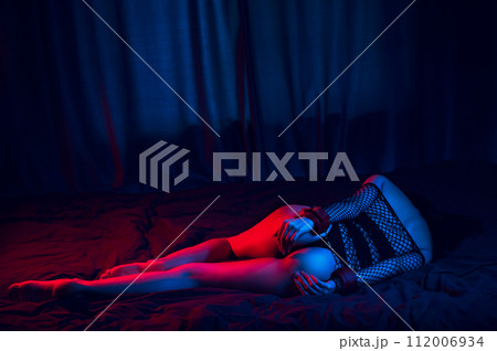 submissive woman with sexy body and ass with hands in BDSM handcuffs lies on bed in bedroom. Slave girl in lingerie for sex with submission and domination submissive woman with sexy body and ass with hands in BDSM handcuffs lies on bed in bedroom. Slave girl in lingerie for sex with submission and domination 112006934