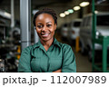 Expert female auto technician at work. Adept african american woman auto mechanic in workshop, showcasing her expertise and command in the field of car technology. 112007989