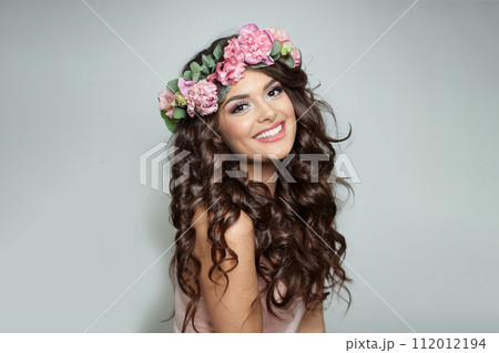 Cheerful woman with make-up, perfect white toothy smile and spring or summer season rose wreath Cheerful woman with make-up, perfect white toothy smile and spring or summer season rose wreath 112012194