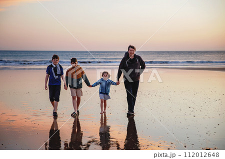 Portrait silhouettes of three children and dad happy kids with father on beach at sunset. happy family, Man, two school boys and one little preschool girl. Siblings having fun together. Bonding Portrait silhouettes of three children and dad happy kids with father on beach at sunset. happy family, Man, two school boys and one little preschool girl. Siblings having fun together. Bonding 112012648