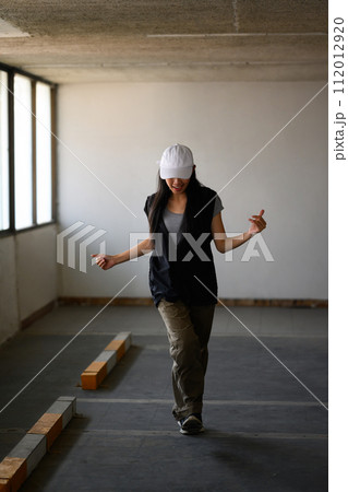 Shot of young woman practicing break dance or freestyle dance in parking garage Shot of young woman practicing break dance or freestyle dance in parking garage 112012920