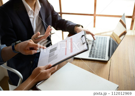 Businessman in black suit sharing information and discussing project developing financial research with colleague 112012969