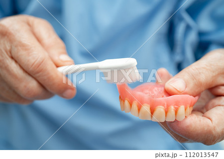 Asian elderly woman patient holding to use denture, healthy strong medical concept. Asian elderly woman patient holding to use denture, healthy strong medical concept. 112013547