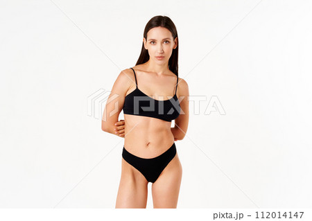 Beautiful sensual slim woman in black underwear on white studio background 112014147