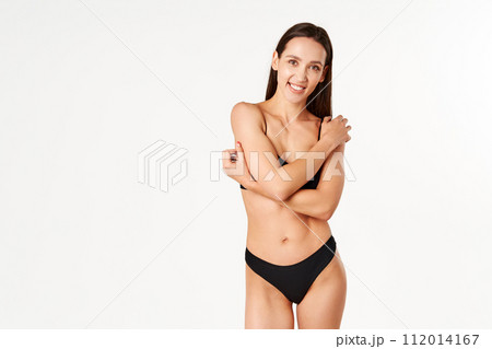 Pretty smiling woman in black underwear posing on white studio background 112014167