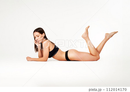 Perfect young woman with sporty body in black underwear lying on floor Perfect young woman with sporty body in black underwear lying on floor 112014170
