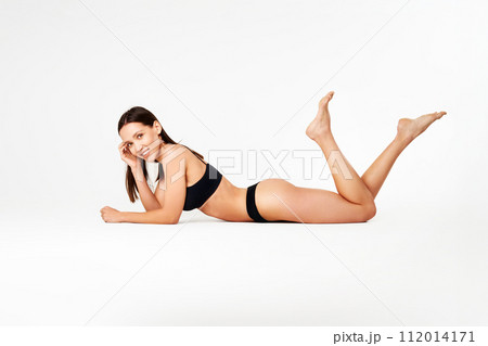Perfect young woman with sporty body in black underwear lying on floor 112014171