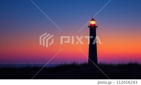 A solitary lighthouse standing against a dusky sky 112016283