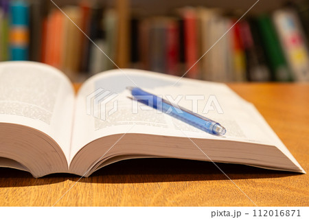 机の上に開いた英語の本とペン 研究 学習のイメージ 机の上に開いた英語の本とペン 研究 学習のイメージ 112016871