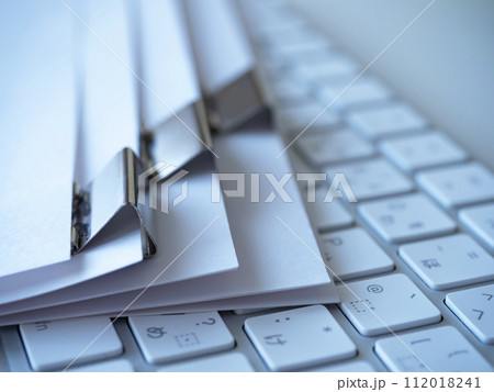テーブルに置かれた書類とキーボード 112018241