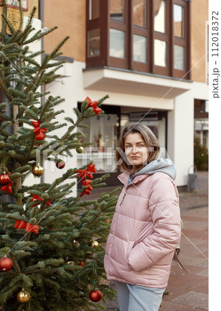 European Elegance: Christmas in Bietigheim-Bissingen. A beautiful girl stands on the street of the old European town of Bietigheim-Bissingen in Germany on Christmas Eve. City streets are decorated 112018372