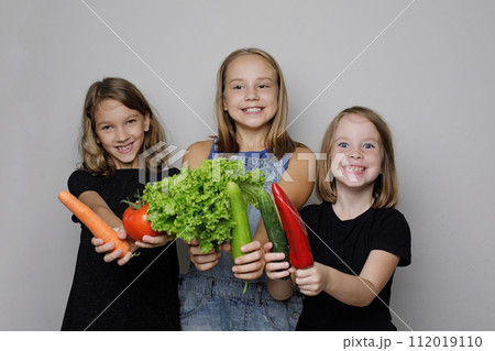 Joyful children with vegetables on white studio wall banner background. Child girls Joyful children with vegetables on white studio wall banner background. Child girls 112019110