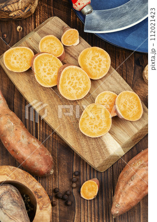 Sweet potatoes on wooden surface Sweet potatoes on wooden surface 112021423