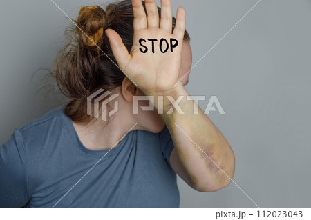 Concept of Stop violence against women. Woman raised her hand with stop inscription for dissuade. Concept of Stop violence against women. Woman raised her hand with stop inscription for dissuade. 112023043