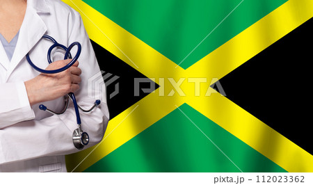 Jamaican medicine and healthcare concept. Doctor close up against flag of Jamaica background Jamaican medicine and healthcare concept. Doctor close up against flag of Jamaica background 112023362