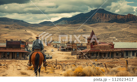 wild west town, modern man dressed as a cowboy on a horse 112023417