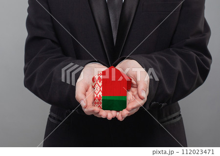 Belarussian person holding wooden house with flag of Belarus Finance, investment, mortgage Belarussian person holding wooden house with flag of Belarus Finance, investment, mortgage 112023471